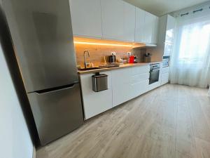 a kitchen with white cabinets and a stainless steel refrigerator at Les Trois Mouettes - Grand appartement familial in Saint-Brieuc +22 photos