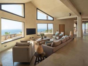 a living room with couches and a tv and windows at Villa Rocca in La Herradura