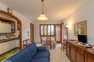 a living room with a blue couch and a kitchen at Villetta a Castiglioncello in Castiglioncello