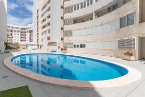 a swimming pool in front of a building at Isabela in Calpe