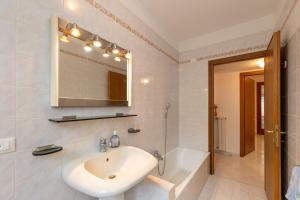 a white bathroom with a sink and a mirror at Villetta a Castiglioncello in Castiglioncello +28 photos