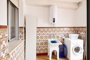 a bathroom with a washing machine and a sink at Casa López in Baena