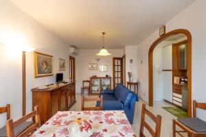 a living room with a table and a blue couch at Villetta a Castiglioncello in Castiglioncello