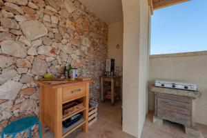 a stone wall in a kitchen with a counter and a table at La casa di Rollo in Otranto