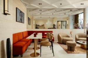 a restaurant with orange furniture and a table and chairs at Jills Hôtel in Paris