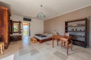 a bedroom with a bed and a desk and a table at La casa di Rollo in Otranto