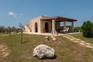 a house with a large rock in front of it at La casa di Rollo in Otranto