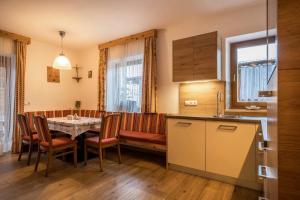 a kitchen and dining room with a table and chairs at Heiserhof App Kirsche in Racines +23 photos