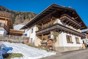 a house in the mountains with snow on the ground at Heiserhof App Kirsche in Racines