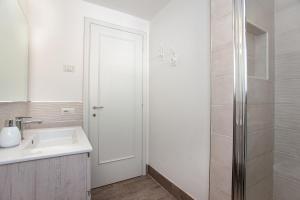 a white bathroom with a sink and a shower at Risveglio con alba in San Teodoro +26 photos