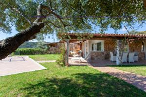 a house with a patio and a tree at Risveglio con alba in San Teodoro