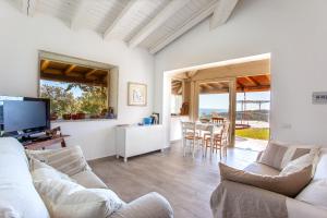 a living room with a couch and a tv at Risveglio con alba in San Teodoro
