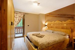 a bedroom with a wooden bed with two shoes on it at Torre St Orso 4061 Maison Gerard in Cogne