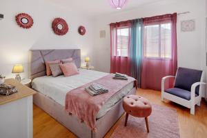 a bedroom with a large bed and a blue chair at Casa da Orquidea in Ribeira Grande