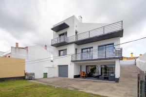 a white house with a balcony at Casa da Orquidea in Ribeira Grande
