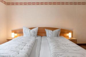 two beds with white blankets and pillows in a bedroom at Ferienwohnung-Reil in Wardenburg