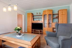 a living room with a couch and a table and a tv at Ferienwohnung-Reil in Wardenburg