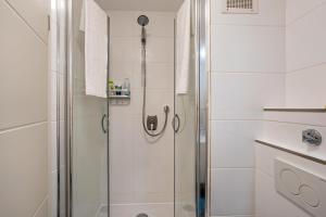 a shower with a glass door in a bathroom at Zentrale Ferienwohnung mit Balkon in Bad Liebenzell +14 photos