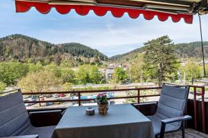 a table and chairs on a balcony with a view at Zentrale Ferienwohnung mit Balkon in Bad Liebenzell