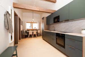 a kitchen with gray cabinets and a dining room at Appartements N°37 in Hüttschlag +65 photos