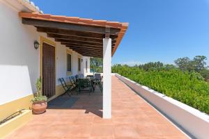 a patio with a table and chairs on a house at Monte do Cerro Verde in Santiago do Cacém
