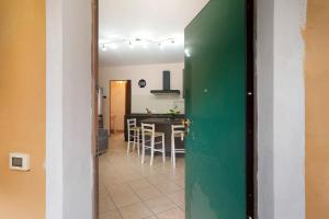 a green door in a room with a table and chairs at Il Frutteto 49 in Ortovero +12 photos