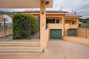 a house with a green door and a fence at Il Frutteto 49 in Ortovero