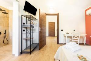 a room with a bed and a table and a television at Su Carinniu in Villacidro