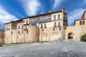 a large stone building with a clock tower at Judería Apartamento in Segovia