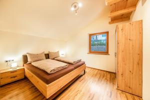 a bedroom with a bed and a wooden floor at Apartement Huck in Cornedo all'Isarco