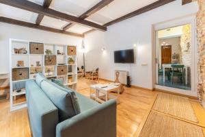 a living room with a blue couch and a table at Judería Apartamento in Segovia