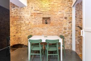 a dining room with a table and chairs against a brick wall at Judería Apartamento in Segovia