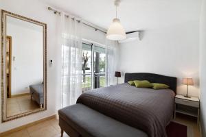 a bedroom with a bed and a mirror at Costa Cabanas 1 in Cabanas de Tavira +16 photos