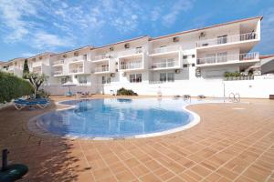a hotel with a swimming pool in front of a building at Costa Cabanas 1 in Cabanas de Tavira
