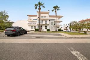 a car parked in a parking lot in front of a building at Costa Cabanas 1 in Cabanas de Tavira