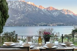 a table with plates and glasses and a bottle of wine at Charming Lake View Bellagio in Bellagio