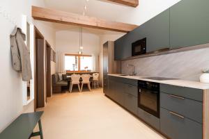 a kitchen with gray cabinets and a dining room at Appartements N°37 in Hüttschlag
