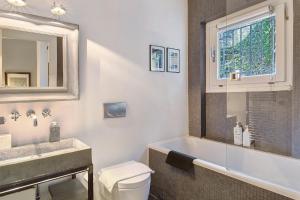 a bathroom with a tub and a toilet and a sink at Charming Lake View Bellagio in Bellagio