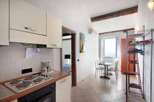 a kitchen with a stove top oven next to a table at Bilocale Serra in Bonassola