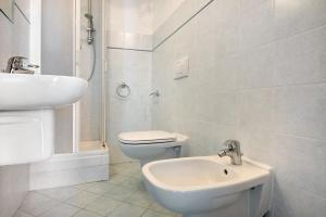 a white bathroom with a toilet and a sink at Bilocale Serra in Bonassola