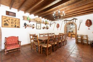 a dining room with a wooden table and chairs at Mansión Piedras Blancas in Colmenar
