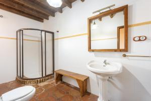 a bathroom with a toilet and a sink and a mirror at Mansión Piedras Blancas in Colmenar +20 photos