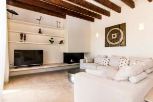 a living room with a white couch and a fireplace at Can Bossa in Capdepera