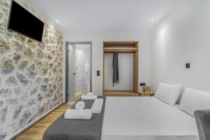 a bedroom with a large white bed and a tv at Groundfloor Studio 1 in Tsoukalades +14 photos