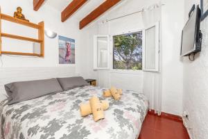 a bedroom with a bed with two teddy bears on it at Cavall Menor in Cala Morell +22 photos