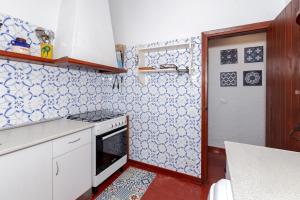 a kitchen with blue and white tiles on the wall at Cavall Menor in Cala Morell