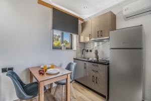 a kitchen with a table and a stainless steel refrigerator at Groundfloor Studio 1 in Tsoukalades