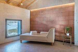 a white couch in a room with a window at Lena Dolomites Luxury Suite in Villnoss