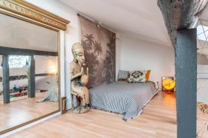 a bedroom with a statue of a man sitting on a bed at En plein centre d'Avignon in Avignon