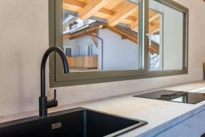 a kitchen with a sink and a window at Lena Dolomites Luxury Suite in Villnoss +22 photos